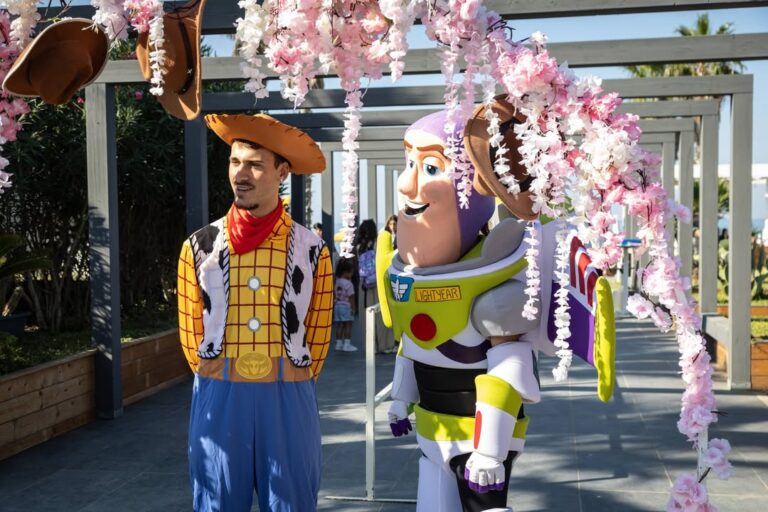 Woody e Buzz Lightyear in costume sotto l'arco di fiori rosa del Varcadoro